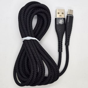 May include: Black USB charging cable with a braided design. The cable has a USB-A connector on one end and a USB-C connector on the other. The cable is coiled and secured with a white tie.