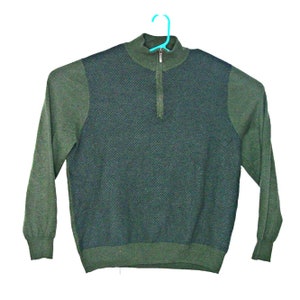 May include: A green long-sleeved sweater with a quarter-zip closure and a textured pattern on the front.