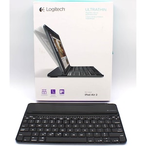 May include: A black Logitech Ultrathin magnetic clip-on keyboard cover for iPad Air 2. The product packaging features a white box with a graphic of the keyboard attached to a tablet, displaying the brand name and model compatibility clearly.