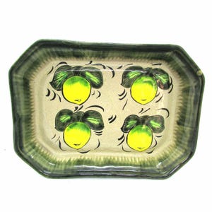 May include: Rectangular ceramic serving tray with a green and beige border. The tray features four yellow lemons with green leaves and black accents. The tray is likely used for serving food or displaying decorative items.