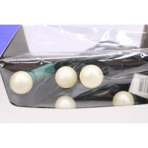 May include: String of pearl-like, off-white decorative lights. The lights are round and evenly spaced along a dark green wire. The lights are packaged in a clear plastic bag.