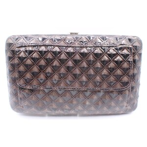 May include: A rectangular, brown handbag with a geometric, diamond-shaped pattern. The bag has a flap closure and a small pocket on the front. The bag is made of a shiny material.