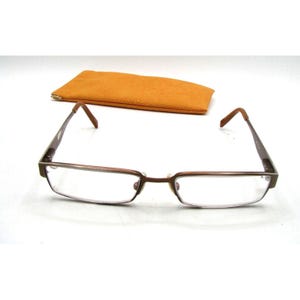 May include: A pair of brown metal eyeglasses with a rectangular frame and clear lenses. The eyeglasses are accompanied by a brown suede case.