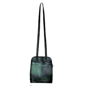Puede incluir: Bolso de hombro de cuero negro con correas largas y finas. El bolso tiene forma rectangular con cierre de cremallera y un peque&ntilde;o detalle plateado. El bolso est&aacute; dise&ntilde;ado para llevarse al hombro.