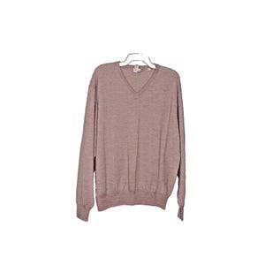 May include: A light brown v-neck sweater with long sleeves.