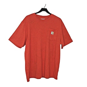 May include: A red short-sleeved t-shirt with a single pocket on the left chest. The pocket has a small yellow logo on it.