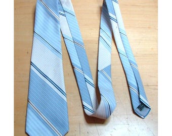 May include: A blue and white striped tie with a brown stripe. The tie is folded in half and laid flat on a wooden surface.