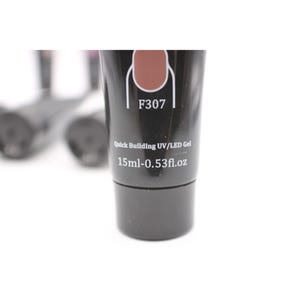 May include: A black tube of Quick Building UV/LED Gel with the label F307. The tube has a brown nail polish swatch and the text "15ml-0.53fl.oz". Other tubes are visible in the background.