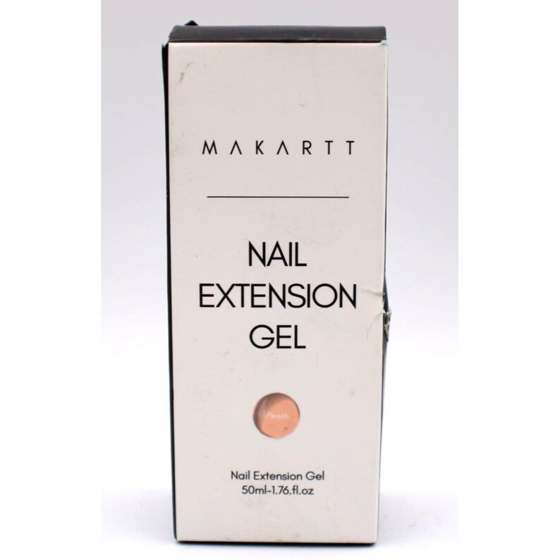 Op de afbeelding: Een witte doos met Makartt Nail Extension Gel. De doos heeft zwarte tekst met de tekst "Makartt", "Nail Extension Gel" en "Peach". De doos heeft ook een perzikkleurige cirkel en de tekst "50ml-1.76 fl.oz".