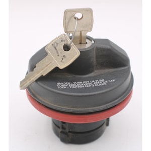 May include: A black locking fuel cap with a red rubber gasket and a silver metal key inserted into the lock. The cap features white printed text that reads: UNLOCK - TURN KEY 1/4 TURN COUNTERCLOCKWISE, REMOVE CAP; LOCK - TIGHTEN CAP 3 CLICKS.