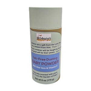 May include: A green and brown cardboard tube with a white label. The label reads "Talc-Free Dusting Baby Powder with Aloe Vera & Vitamin E". The label also says "Naturally scented with plant oils "from the Garden of Eden" Net wt 6 oz (170 g)"