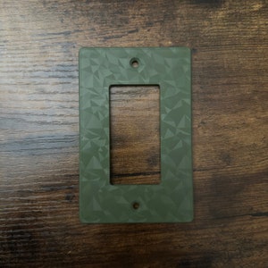 以下が含まれることがあります： 幾何学模様の緑色のプラスチック製のライトスイッチカバー