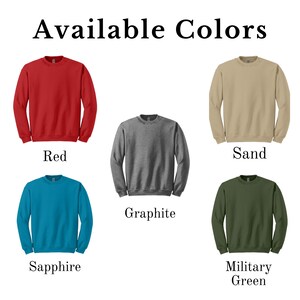 May include: Image displays five crewneck sweatshirts in various colors: red, graphite, sand, sapphire, and military green. The text "Available Colors" is at the top, with each sweatshirt color labeled below. The sweatshirts are displayed on a white background.