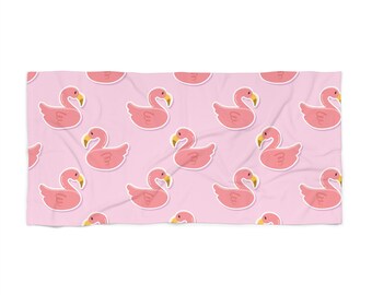 Op de afbeelding: Roze strandhanddoek met een herhalend patroon van roze flamingo's met het woord "Love" erop.