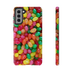 May include: A colorful phone case with a pattern of jelly beans in various colors, including red, orange, yellow, green, and purple.