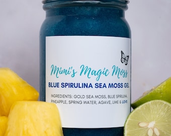May include: A glass jar with a white lid filled with a blue gel. The label reads "Mimi's Magic Moss Blue Spirulina Sea Moss Gel" and lists the ingredients: "Gold Sea Moss, Blue Spirulina, Pineapple, Spring Water, Agave, Lime & Love".