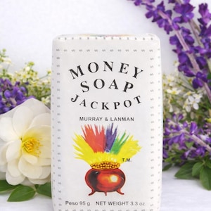 May include: White rectangular bar of "Money Soap Jackpot" by Murray & Lanman. The label features a pot of gold with rainbow colors and the text "Money Soap Jackpot". The soap weighs 3.3 oz.