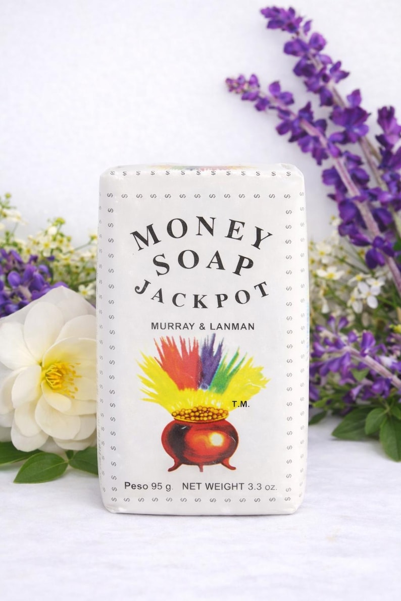 May include: White rectangular bar of "Money Soap Jackpot" by Murray & Lanman. The label features a pot of gold with rainbow colors and the text "Money Soap Jackpot". The soap weighs 3.3 oz.