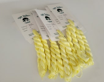 May include: Eight skeins of bright yellow embroidery floss, each with a label that reads "Night Stalkers Calling", "Colorway: Marigolds", "Dye Lot: #10", and "Yards: 10".