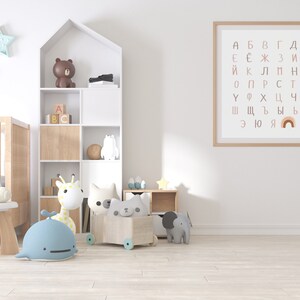 May include: A white nursery with a crib, a wooden bookshelf with a brown bear, a giraffe, and a whale toy, a wooden toy chest with a cat toy, and a framed poster with the Cyrillic alphabet and a rainbow.