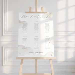 Könnte beinhalten: Ein Sitzplan für eine Babyparty, der auf einer Staffelei präsentiert wird. Die Tafel hat eine weiche, neutrale Farbpalette mit Wolken- und Sternakzenten. Der Text "Please Find Your Seat" steht oben, mit den Namen der Gäste, die nach Tischnummer geordnet sind. Die Babyparty ist für Olivia, am 07.08.20xx.