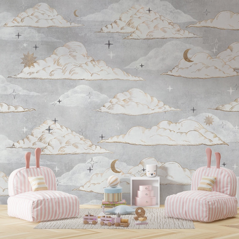 May include: A grey wallpaper featuring a repeating pattern of white and gold-toned clouds, crescent moons, and stars. Two pink and white striped chairs with rabbit-ear backrests sit on a rug in front of the wall, alongside a small white shelf.