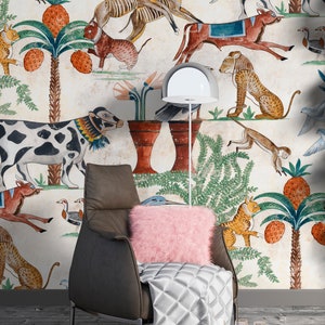 May include: A dark brown leather armchair with a pink faux fur pillow and a silver quilted throw blanket. The chair is positioned against a wall covered in wallpaper featuring a repeating pattern of various animals, palm trees, and pineapples.