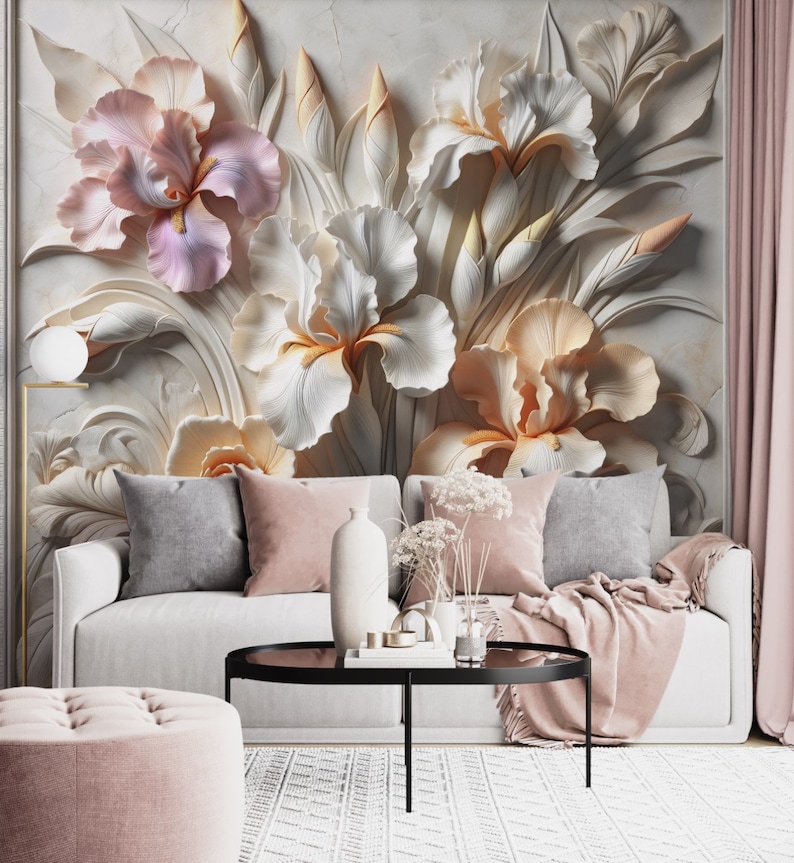 May include: A wall mural featuring large, three-dimensional sculpted iris flowers in shades of soft pink, cream, and white. The floral design is set against a textured, light-coloured background, creating a layered, relief-like appearance.