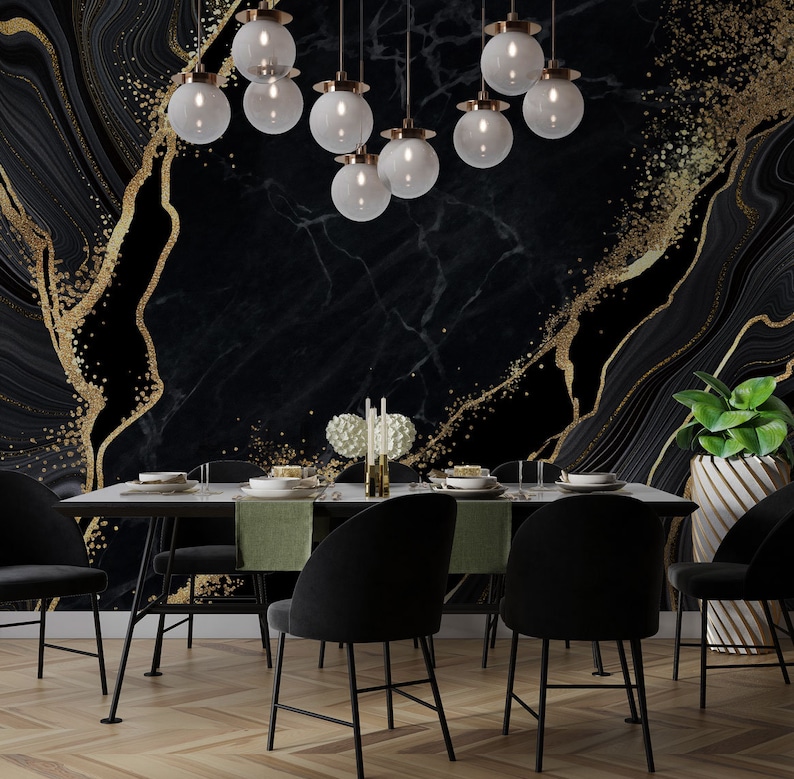 May include: A dining room featuring a black marble wall mural with gold glitter accents, a rectangular table with green runners, six black upholstered chairs, a cluster of nine spherical glass pendant lights, and a green plant in a white planter.