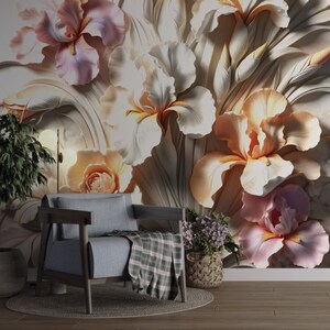 May include: A grey armchair with a plaid throw blanket sits before a wall mural featuring large, three-dimensional relief-style iris flowers in shades of soft pink, cream, and peach, accompanied by a potted plant and a small basket of purple flowers.