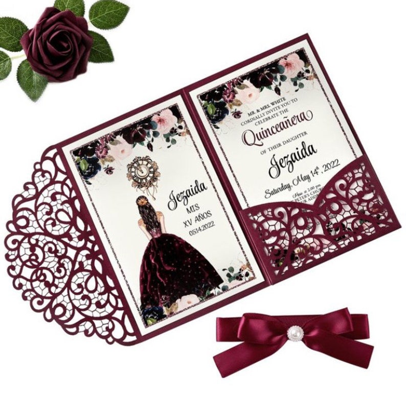 May include: Burgundy laser-cut invitation with a floral design and a pocket for a RSVP card. The invitation is for a Quincea&ntilde;era celebration for Jezaida on May 14, 2022.