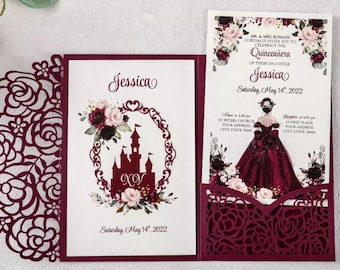 May include: Burgundy red laser cut invitation with a white insert featuring a castle silhouette and floral design. The text on the insert reads "Jessica" and "Saturday, May 14, 2022". The invitation is for a Quinceañera.