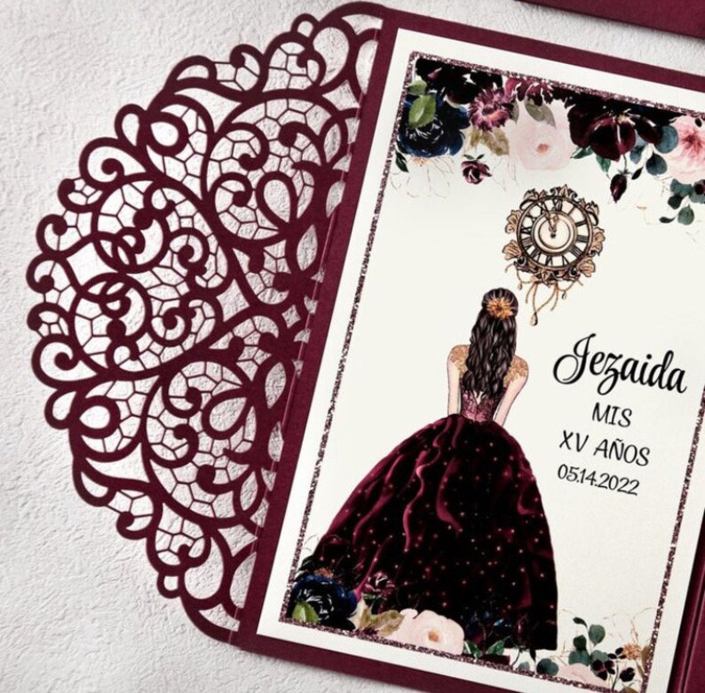 May include: Burgundy laser cut invitation with a white insert featuring a drawing of a woman in a burgundy gown, a clock, and floral accents. The text reads "Jezaida Mis XV A&ntilde;os 05.14.2022".