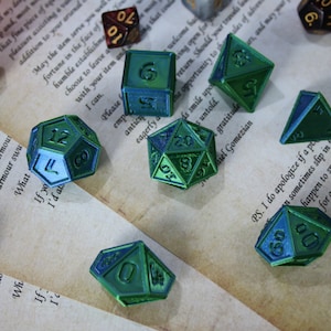May include: A set of ten metallic green and blue dice with various numbers on each face. The dice are scattered on a piece of paper with text.