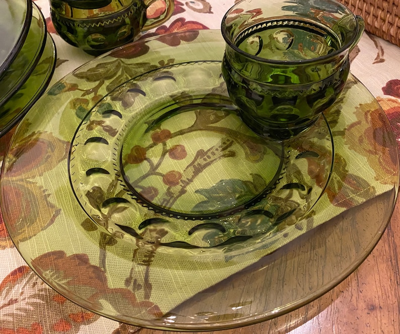 Puede incluir: Un juego de platos de vidrio verde con un dise&ntilde;o texturizado. El juego incluye un plato peque&ntilde;o, una taza y un platillo.
