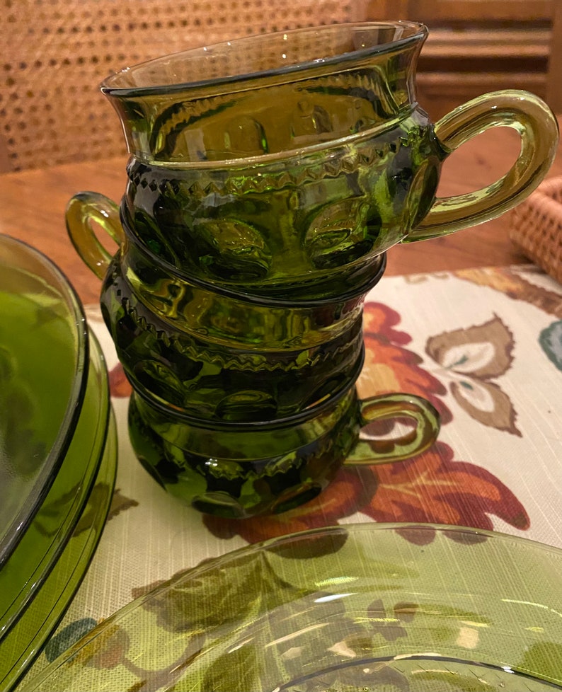 Puede incluir: Un juego de cuatro tazas de vidrio verde con un dise&ntilde;o texturizado. Las tazas est&aacute;n apiladas una encima de la otra.