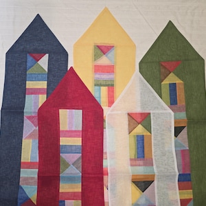 May include: Five fabric house decorations in navy, red, yellow, white, and green. Each house has a triangular roof and a rectangular body with a geometric pattern in the centre, using a variety of colours including blue, red, and yellow.