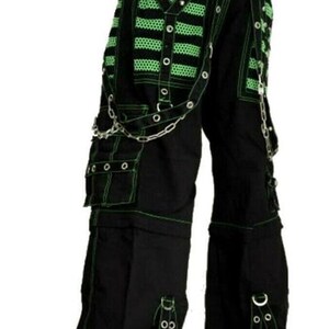 May include: Black cargo pants with green stitching and multiple straps and buckles. The pants have a chain detail and large pockets.