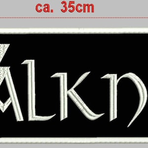 Puede incluir: Parche bordado en blanco y negro con la palabra "WALKNUT" en una fuente estilizada y un diseño de nudo triangular blanco. El parche mide aproximadamente 10 cm de alto y 35 cm de ancho.