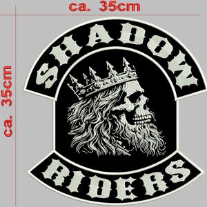May include: A large black and white embroidered patch featuring a skull wearing a crown with long hair and a beard. The text SHADOW is arched above and RIDERS is arched below. The patch measures approximately 35cm by 35cm as indicated by the red text.