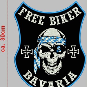Puede incluir: Parche bordado en blanco y negro con una calavera que lleva un pañuelo a cuadros azul y blanco. La calavera tiene un parche en el ojo azul con un diseño de calavera y huesos cruzados. El parche también presenta el texto "FREE BIKER" y "BAVARIA" en bordado blanco. El parche mide aproximadamente 25 cm de ancho y 30 cm de alto.