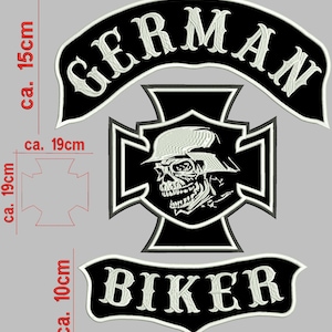 Könnte beinhalten: Schwarz-weiße, gestickte Biker-Patches. Die Patches enthalten die Wörter "GERMAN" und "BIKER" in weißer Schrift. Ein Schädel mit Helm ist auf einem kreuzförmigen Patch zentriert. Der "GERMAN" Patch ist ca. 30 cm breit.