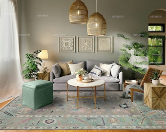 May include: A living room with a gray sofa, a green ottoman, a coffee table, and a rug with a floral pattern. There are two hanging wicker pendant lights and two framed pieces of art on the wall. There are plants in the room, including a large potted plant in the corner.