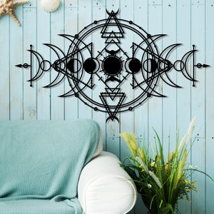 May include: Black metal wall decor with a geometric design featuring circles, triangles, and crescent moons. The design is reminiscent of a celestial or astrological symbol.
