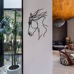 May include: A black metal horse head wall sculpture with a minimalist design. The sculpture is mounted on a white wall in a modern home.