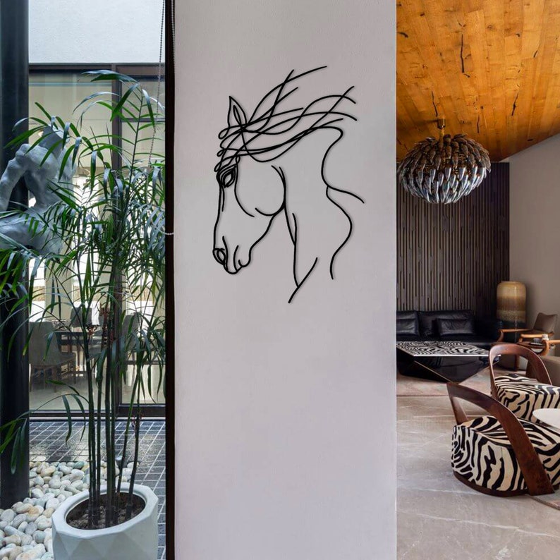May include: A black metal horse head wall sculpture with a minimalist design. The sculpture is mounted on a white wall in a modern home.