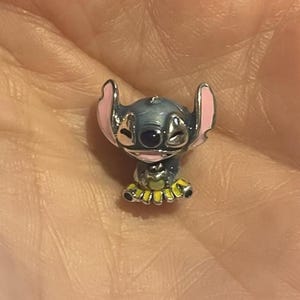 May include: A white ceramic mug with a black handle and the text "But First, Coffee" in a handwritten style. The mug is on a white surface. The mug is approximately 10 cm tall.