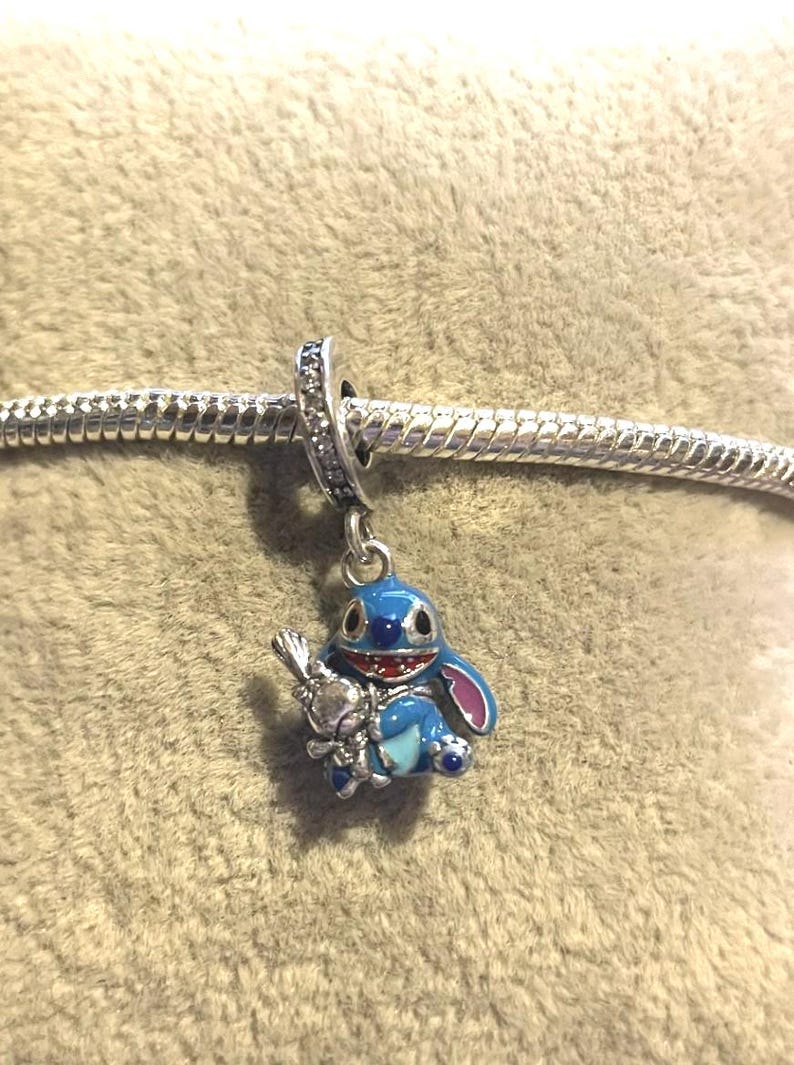 May include: A trio of cream-glazed ceramic mugs, each adorned with a hand-painted floral design. The flowers are rendered in blue, green, and yellow hues. The mugs have a rounded form and a practical handle, ideal for tea or coffee.