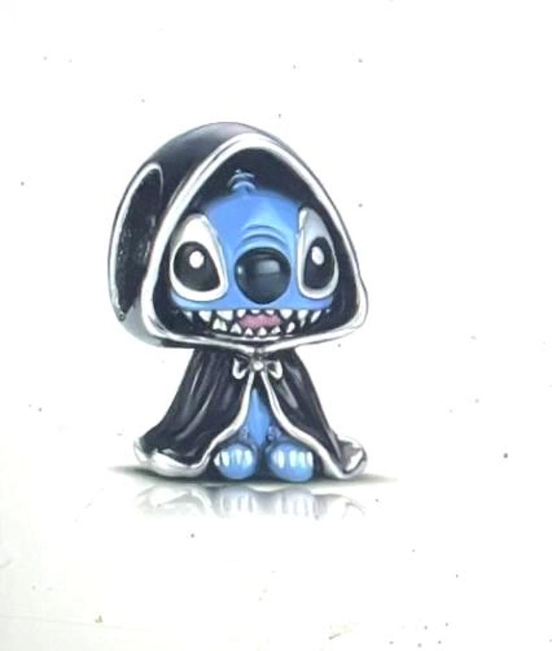 May include: A blue character with large eyes and a mischievous grin, wearing a black hooded cloak with silver trim. The figure has a small body and is standing on a white surface. The character is a stylized representation of Stitch.