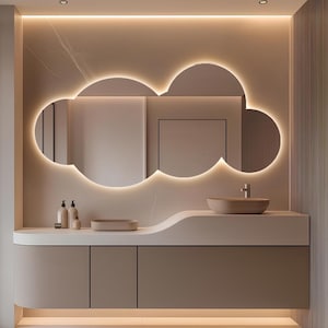 May include: A modern bathroom vanity with a cloud-shaped mirror featuring a warm, glowing LED outline. The vanity has a curved countertop, a vessel sink, and a cabinet with three doors. The color scheme is neutral, with beige and light brown tones.